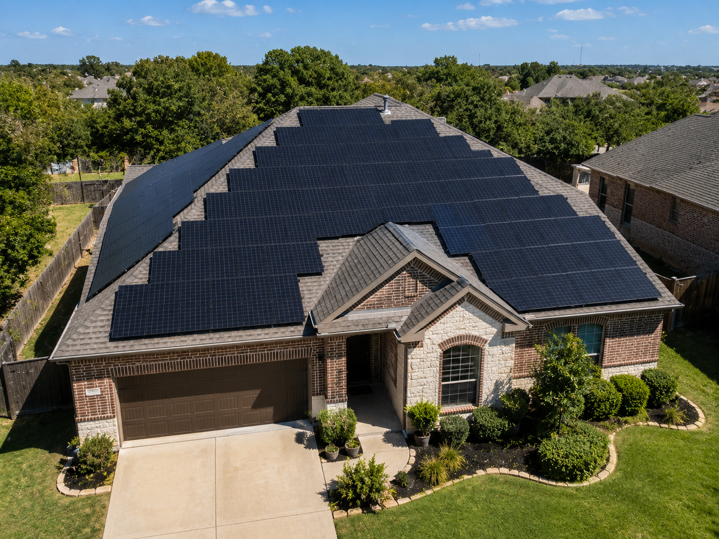 Aerial view of a Texas brick home with solar panels covering much of the roof